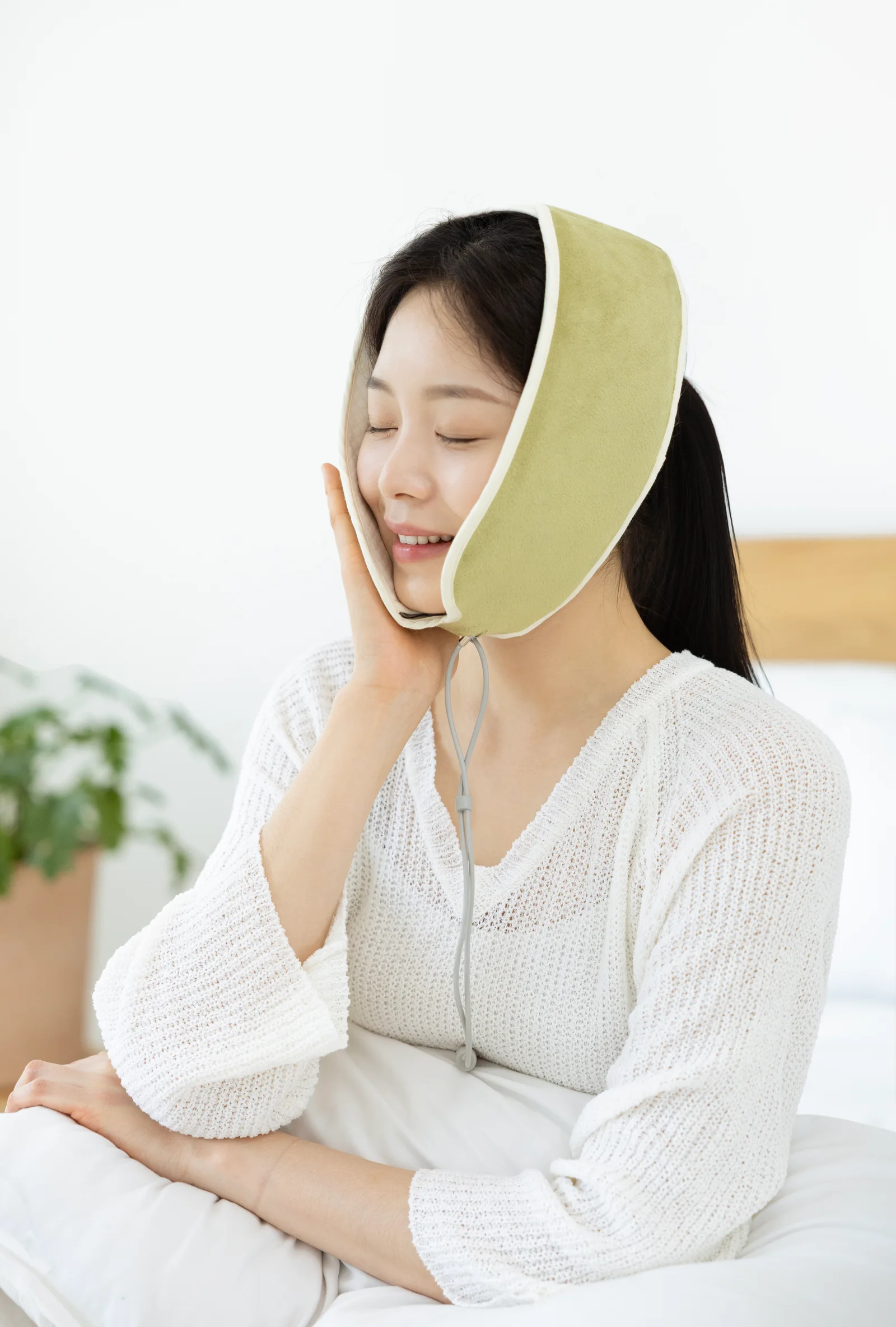 올리브 찜질기를 턱과 관자놀이에 착용한 모습