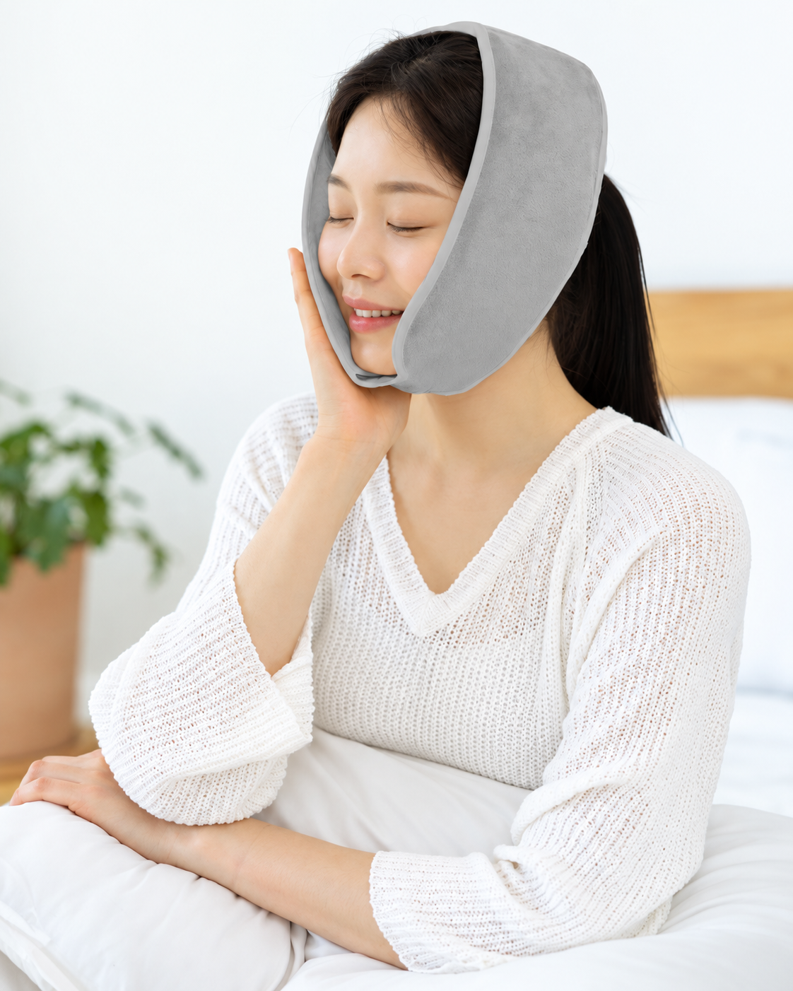 턱 아래에서 양쪽 관자놀이까지 이어지는 황토 찜질팩 착용 형태