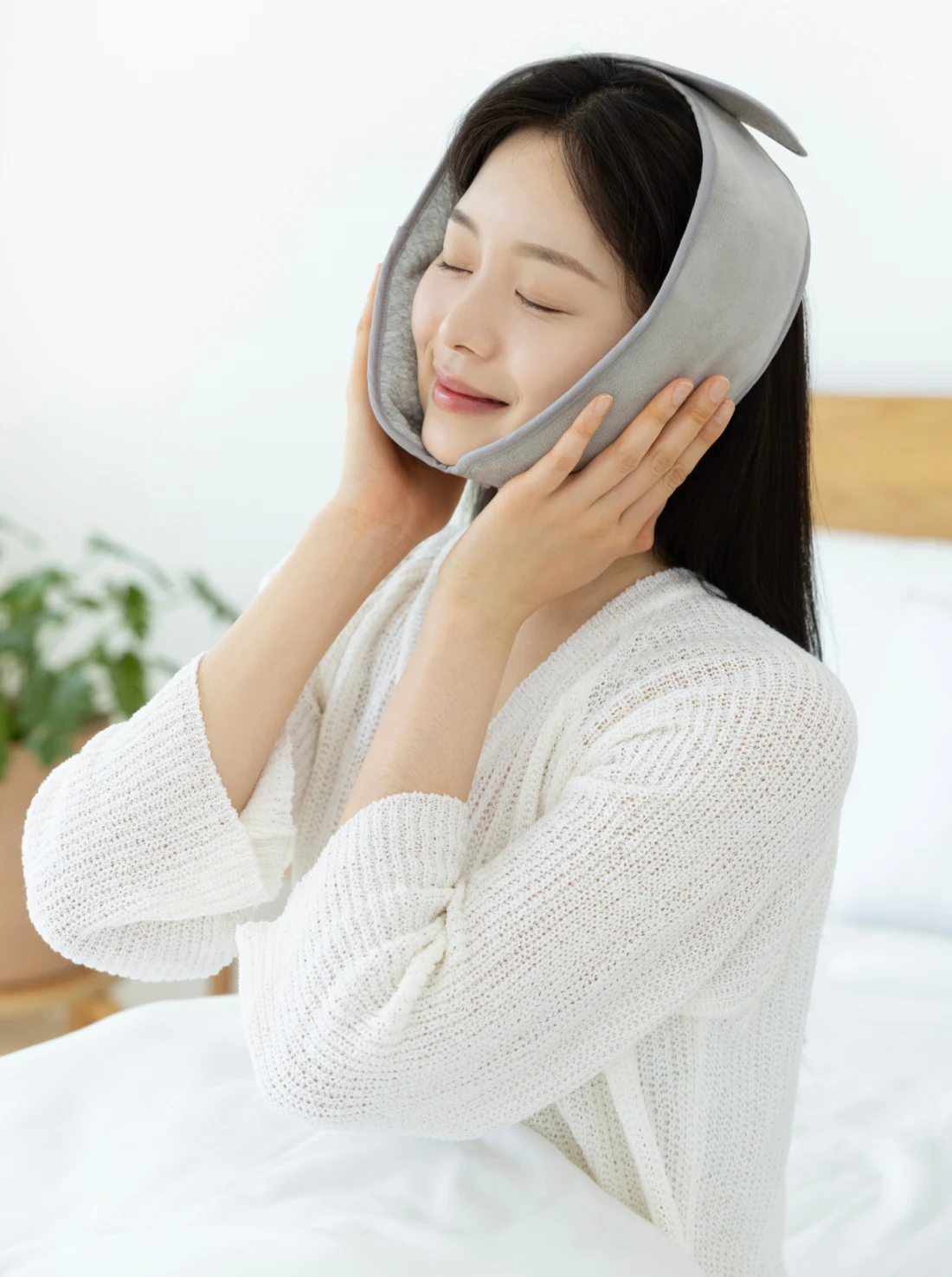 황토 찜질팩으로 턱 주변과 관자놀이를 감싼 착용 모습